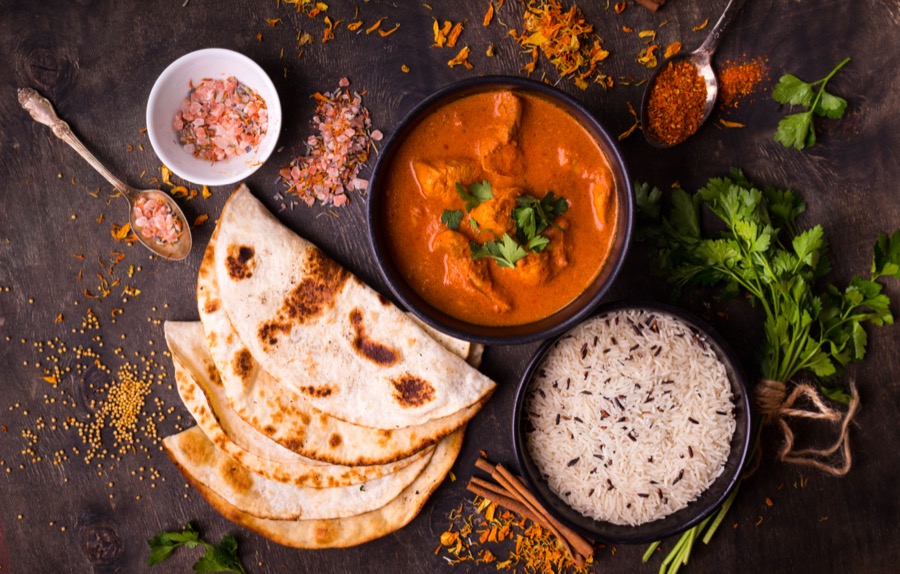 Butter chicken served with naan and rice.